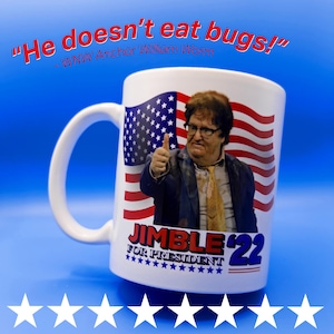 May include: White ceramic mug with a portrait of a man giving a thumbs-up, and an American flag design. The mug has the text "JIMBLE '22 FOR PRESIDENT" and "He doesn't eat bugs!" - WNW Anchor William Worm.