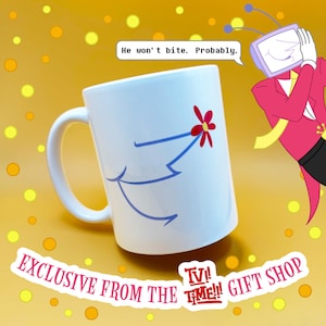 May include: White ceramic mug with a whimsical design featuring a red flower and blue lines. The mug has the text "He won't bite. Probably." and "EXCLUSIVE FROM THE TV TIME!! GIFT SHOP" on a yellow background.