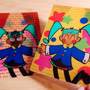 May include: Two rectangular cards with cartoon illustrations. One card has a red background with the text "Are you still watching?" repeated. The other card has a yellow background with colourful stars and a cartoon character in a blue outfit.