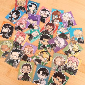 May include: A selection of colourful character stickers in a cartoon style. Each sticker depicts a unique anime-inspired character with distinct hairstyles, facial expressions, and outfits. The stickers are arranged on a light brown wooden surface.