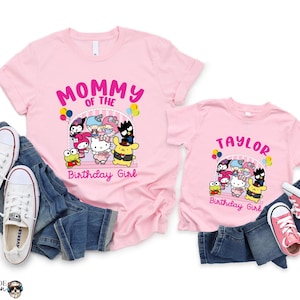 May include: Pink t-shirts with a graphic of Hello Kitty and friends. The larger shirt says "Mommy of the Birthday Girl" and the smaller shirt says "Taylor Birthday Girl".