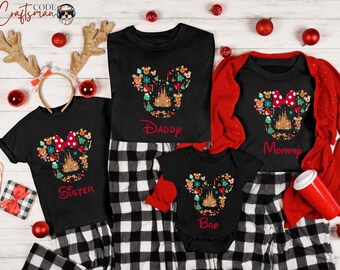 Könnte beinhalten: Ein Set aus vier schwarzen T-Shirts mit einem Weihnachts-Mickey-Mouse-Motiv. Die Shirts sind mit den Worten "Schwester", "Papa", "Mama" und "Bruder" bedruckt. Die Shirts liegen auf einem schwarz-weiß karierten Hintergrund.