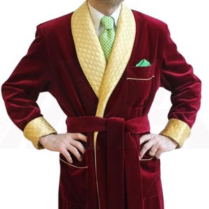 May include: A red velvet robe with gold trim and a shawl collar. The robe has a belt and two pockets.