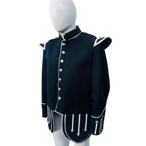 May include: A black jacket with white piping and silver buttons. The jacket has a high collar and a long, pointed tail. The jacket is made of a thick, durable fabric.