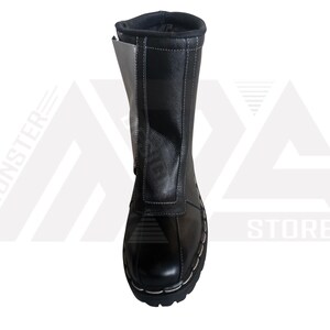 May include: Black leather boots with a white panel on the side. The boots have a lace-up closure and a thick sole.