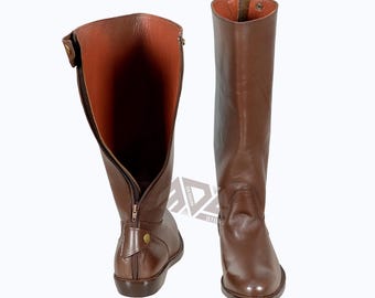 May include: A pair of brown leather boots with a zipper on the inside of each boot. The boots have a pointed toe and a low heel.