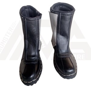 May include: A pair of black and grey leather boots with a zipper on the side. The boots have a stitched seam around the top and bottom of the boot.