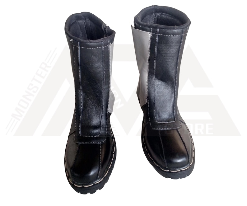 May include: A pair of black and grey leather boots with a zipper on the side. The boots have a stitched seam around the top and bottom of the boot.