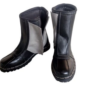 May include: A pair of black leather boots with a zipper on the side. One boot has a gray panel on the side.