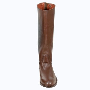 May include: A pair of brown leather riding boots with a pointed toe and a zipper on the back.