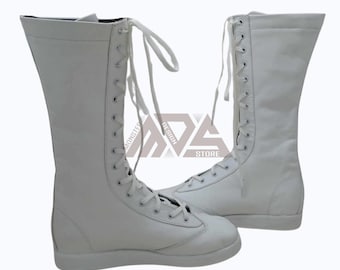 May include: A pair of white leather boxing boots with laces. The boots are tall and have a flat sole.