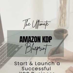 May include: A laptop computer and notebook with the text "The Ultimate AMAZON KDP Blueprint Start & Launch a Successful KDP Business NO RESELL RIGHTS Mom's Gone Digital" on a white surface.