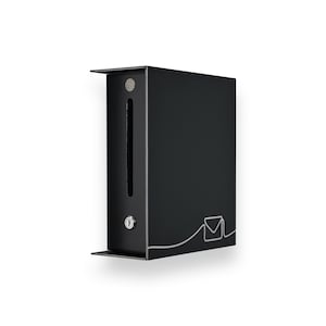 May include: Black metal mailbox with a lock and a slot for mail. The mailbox has a minimalist design with a small shelf at the bottom and a decorative outline of an envelope on the side. The mailbox is mounted on a white background.