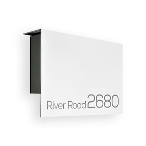 Może przedstawiać: Biała skrzynka pocztowa z czarnym wierzchołkiem i nadrukiem "River Road 2680" w kolorze szarym.