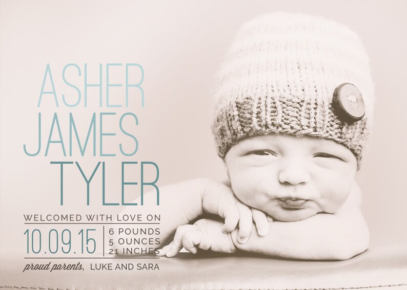 May include: A newborn baby boy named Asher James Tyler, wearing a knitted hat with a button, is pictured on a light brown background. The baby is 6 pounds, 5 ounces, and 21 inches long. The text "Welcomed with love on 10.09.15" is displayed above the baby's image. The text "proud parents, LUKE AND SARA" is displayed below the baby's image.