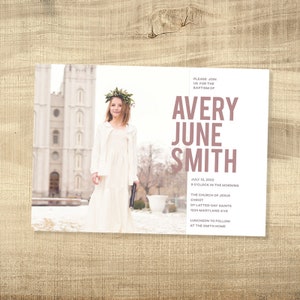 May include: A white invitation card with a photo of a young girl wearing a white dress and a flower crown. The text on the card reads "Please join us for the baptism of Avery June Smith July 12, 2022 9 o'clock in the morning The Church of Jesus Christ of Latter-day Saints 1234 Maryland Ave Luncheon to follow at the Smith Home"