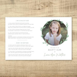 May include: A white card with green floral borders and a photo of a young girl in a white shirt. The card has the text "I am a child of God" and "Welcome to the Baptism of Lana Ann Winters".