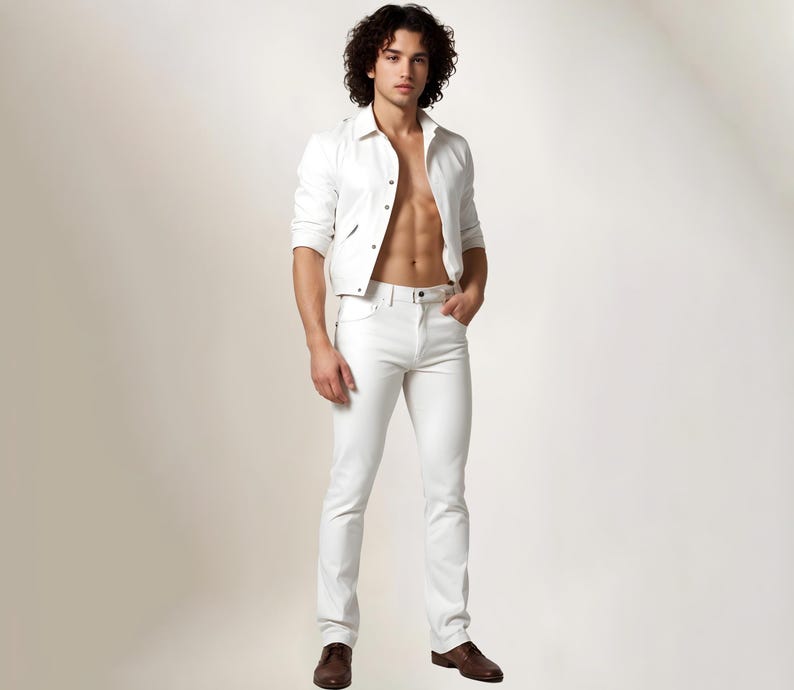 May include: A man wearing a white denim jacket and white jeans. He is standing with his hands in his pockets and looking at the camera.