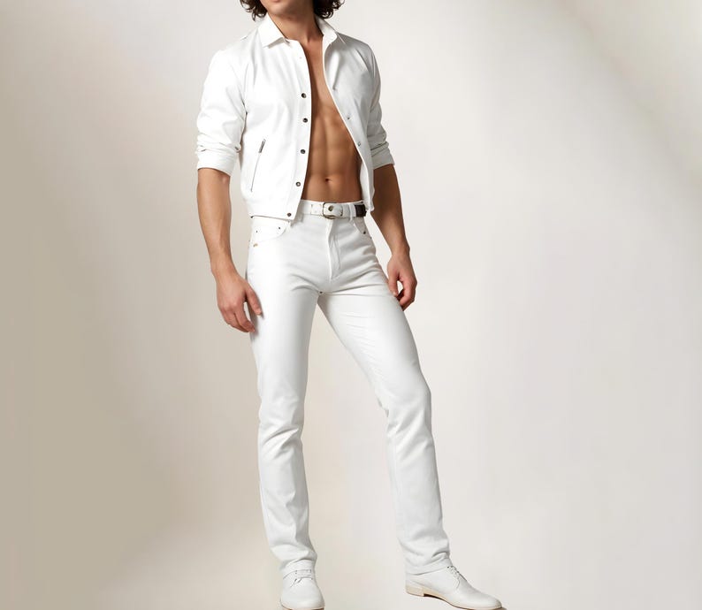 May include: A white leather jacket with a zipper closure and a white button-down shirt underneath. The person is wearing white jeans with a thin black belt.
