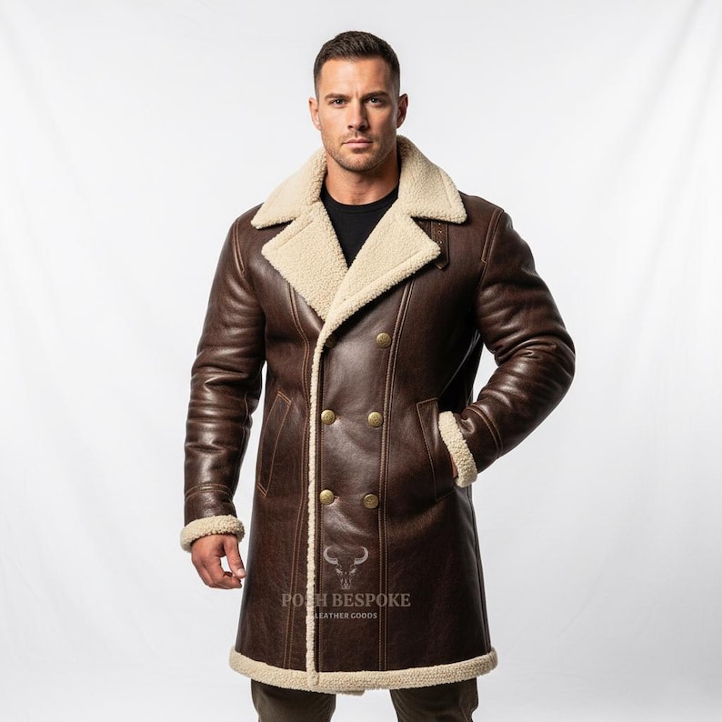 May include: A brown leather coat with a cream-colored shearling lining and trim. The double-breasted coat features gold-colored buttons and a notched collar. The coat has a long length, reaching the mid-thigh.