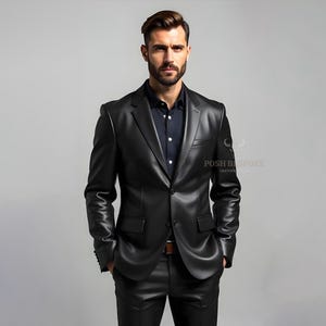 Könnte beinhalten: Ein schwarzer Lederblazer und eine passende Hose. Der Blazer hat ein fallendes Revers, zwei Vordertaschen und einen Ein-Knopf-Verschluss. Das Outfit wird mit einem dunkelblauen Hemd getragen. Der Text "POSH BESPOKE LEATHER" ist sichtbar.