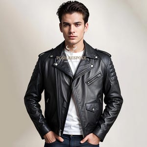 Könnte beinhalten: Eine schwarze Lederjacke im Motorrad-Stil mit Reißverschluss und gestepptem Schulterdesign. Die Jacke hat eine Reißverschlusstasche am linken Ärmel und zwei Reißverschlusstaschen vorne. Die Jacke wird von einer Person mit einem weißen T-Shirt darunter getragen.