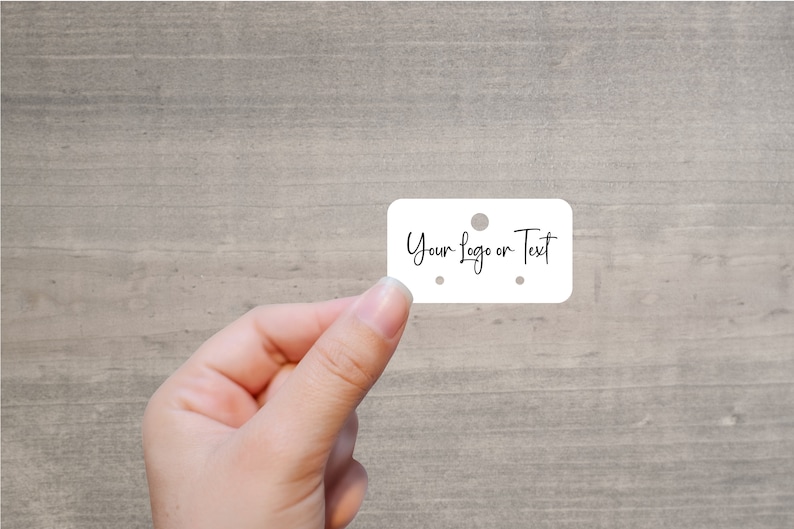 May include: White rectangular tag with rounded corners and three holes. The tag says "Your Logo or Text" in black cursive writing.