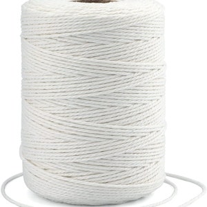 May include: A spool of white cotton twine. The twine is wound tightly around the spool and is ready to be used for crafting, gardening, or other projects.