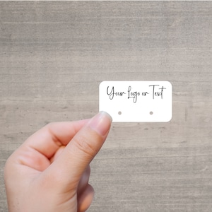 May include: White rectangular tag with two holes for hanging. The tag says "Your Logo or Text" in black cursive writing.
