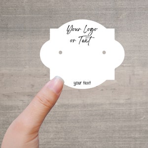 May include: White earring display card with two holes for earrings. The card has a scalloped edge and the text "Your Logo or Text" at the top. The text "your text" is at the bottom of the card.