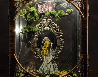 May include: A decorative lantern with an Alice in Wonderland theme. The bronze-colored lantern features a detailed frame, a mirror with Alice, and a Cheshire Cat illustration. The interior is lit with small lights, creating a whimsical display.