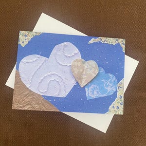 Trio de coeurs flottant dans une carte de voeux de ciel étoilé.