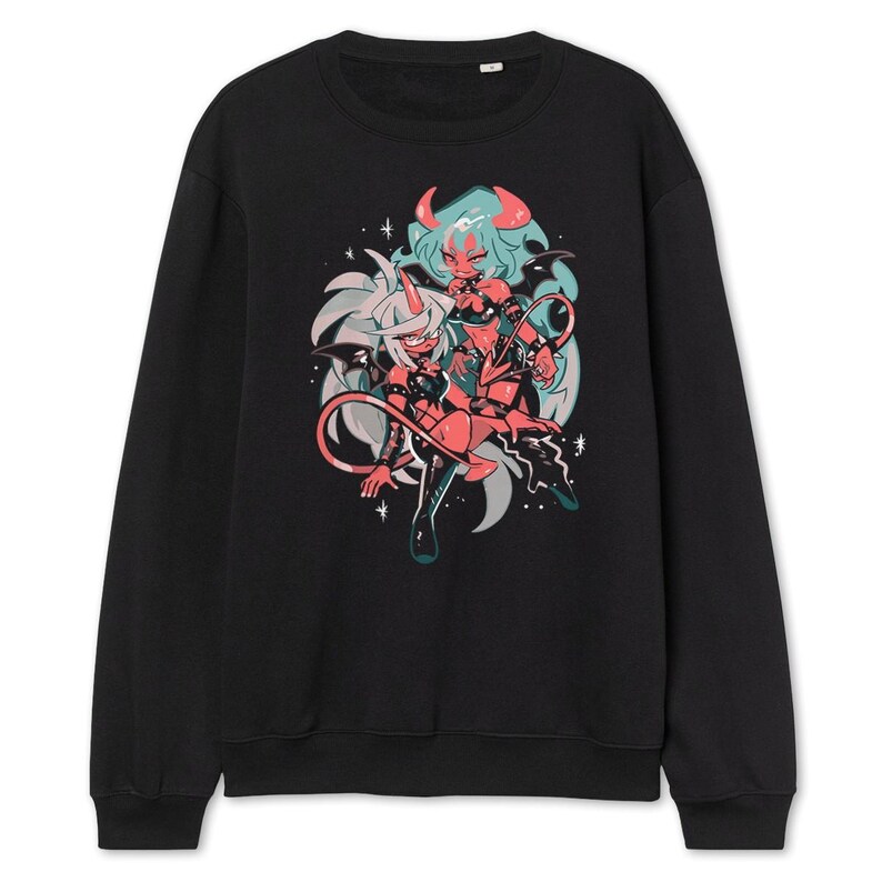 May include: Black sweatshirt featuring a colorful graphic of two anime-style characters with horns, tails, and wings. The artwork includes shades of red, teal, and white, set against a black background. The design has a cartoonish style.