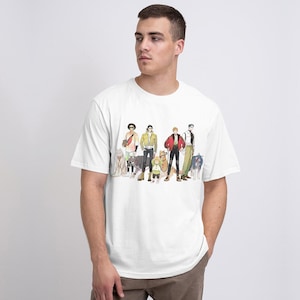 May include: White t-shirt with a graphic print of seven cartoon characters, including a group of men and a small child, all with dogs. The characters are wearing casual clothing and standing in a line.
