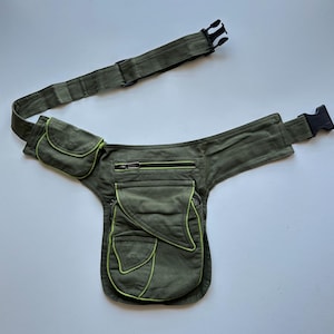 May include: Olive green fanny pack with multiple pockets and a black buckle closure. The pockets are outlined with neon green stitching. The adjustable strap and the main body of the pack are made of a durable fabric.