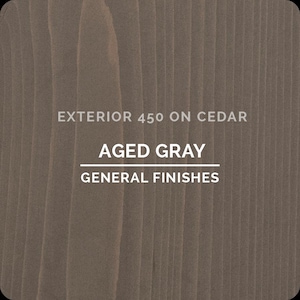 May include: A close-up of a wood grain pattern stained in Aged Gray. The text "EXTERIOR 450 ON CEDAR", "AGED GRAY", and "GENERAL FINISHES" are displayed in white font.