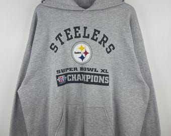 May include: A heather gray hooded sweatshirt featuring the black text Steelers arched above the team logo. Below the logo, the text reads Super Bowl XL Champions in black, with a small Super Bowl XL graphic emblem positioned to the left.