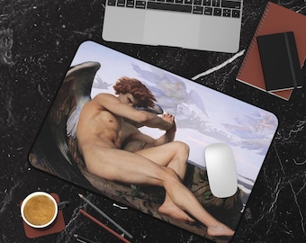 May include: A mousepad featuring a painting of a winged angel with a sorrowful expression, sitting on a rock with a cloudy sky in the background.