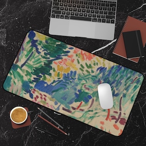 Può includere: Un tappetino per mouse rettangolare con un dipinto astratto con pennellate blu, verdi, gialle e rosse. Un mouse per computer bianco è sul tappetino, con un laptop, quaderni e una tazza di caffè nelle vicinanze.