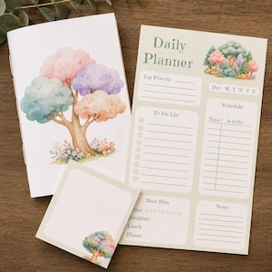 May include: A stationery set featuring a notebook, a daily planner sheet, and a square notepad. The notebook cover displays a watercolor tree with pastel foliage. The planner includes sections for priorities, schedule, meal plan, and notes.