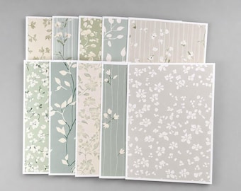May include: A collection of ten rectangular greeting cards featuring various botanical patterns in shades of sage green, cream, white, and soft gray. The designs include floral motifs, delicate leaf vines, and vertical stripes on paper stock.