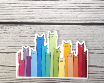 May include: A sticker featuring a row of tall, slender cartoon cats in a rainbow gradient of colors. Each cat has a simple face with two dots for eyes and whiskers. The cats vary in height, creating a skyline effect with shades of pink, purple, blue, green, yellow, orange, and red.