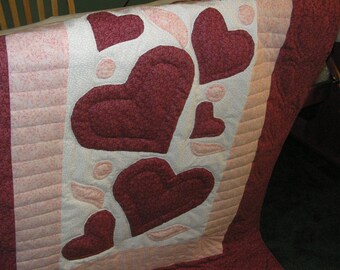 Edredón de corazones en tonos burdeos y rosa, acolchado a mano