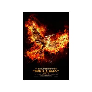 May include: A movie poster for "The Hunger Games: Mockingjay Part 2" featuring a golden bird with outstretched wings flying through flames against a black background. The text "The Hunger Games: Mockingjay Part 2" is at the bottom of the poster, along with the release date "November 20".
