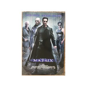 May include: A metal sign featuring the movie poster for "The Matrix." The poster shows four characters, with Keanu Reeves and Laurence Fishburne's names at the top. The word "MATRIX" is prominently displayed in the center, with a dark, futuristic aesthetic.