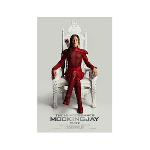 May include: Movie poster for The Hunger Games: Mockingjay Part 2. The poster features a woman in a red outfit sitting on a white throne. The text on the poster reads "The Hunger Games: Mockingjay Part 2. The fire will burn forever. November 20."
