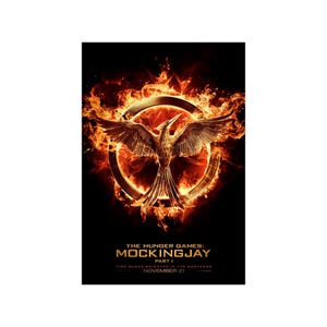May include: A movie poster for The Hunger Games: Mockingjay Part I. The poster features a fiery phoenix in a circle with the title of the movie and the release date, November 21.