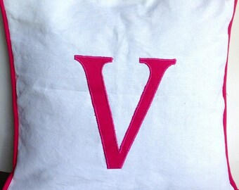 May include: White pillow with a pink embroidered letter V.