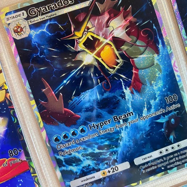 May include: A Gyarados Pokemon card from the Pokemon Trading Card Game. The card features a blue and red illustration of Gyarados with the text "Hyper Beam" and "100" on the card.