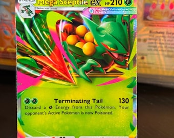 Könnte beinhalten: Eine Mega Sceptile EX Pokémon-Karte. Die Karte zeigt ein grünes, reptilienartiges Wesen mit gelben Kugeln und rosa Akzenten. Der Text enthält "Mega Sceptile EX" und "Terminating Tail". Die Karte befindet sich in einem transparenten Kunststoffhalter.